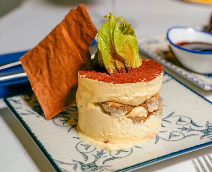 A layered cream dessert with cocoa and physalis