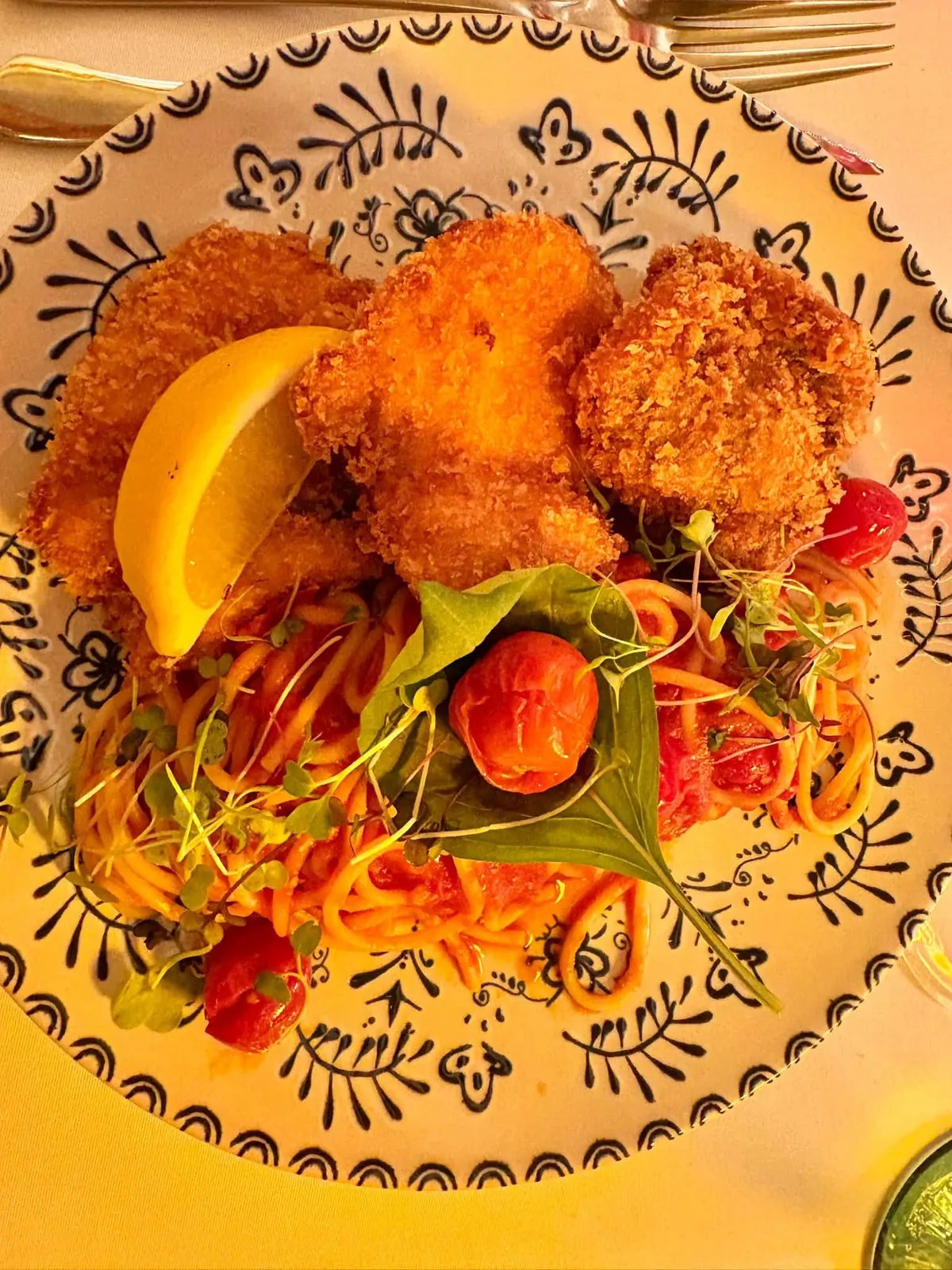 Golden fried bites with lemon over spaghetti