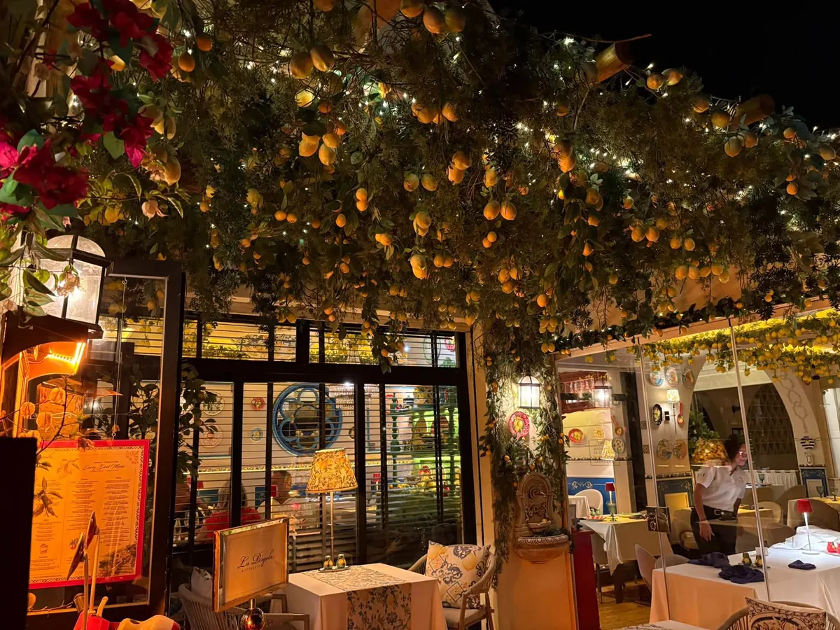 La Pergola's terrace at night, beneath a pergola hung with lemons and fairy lights
